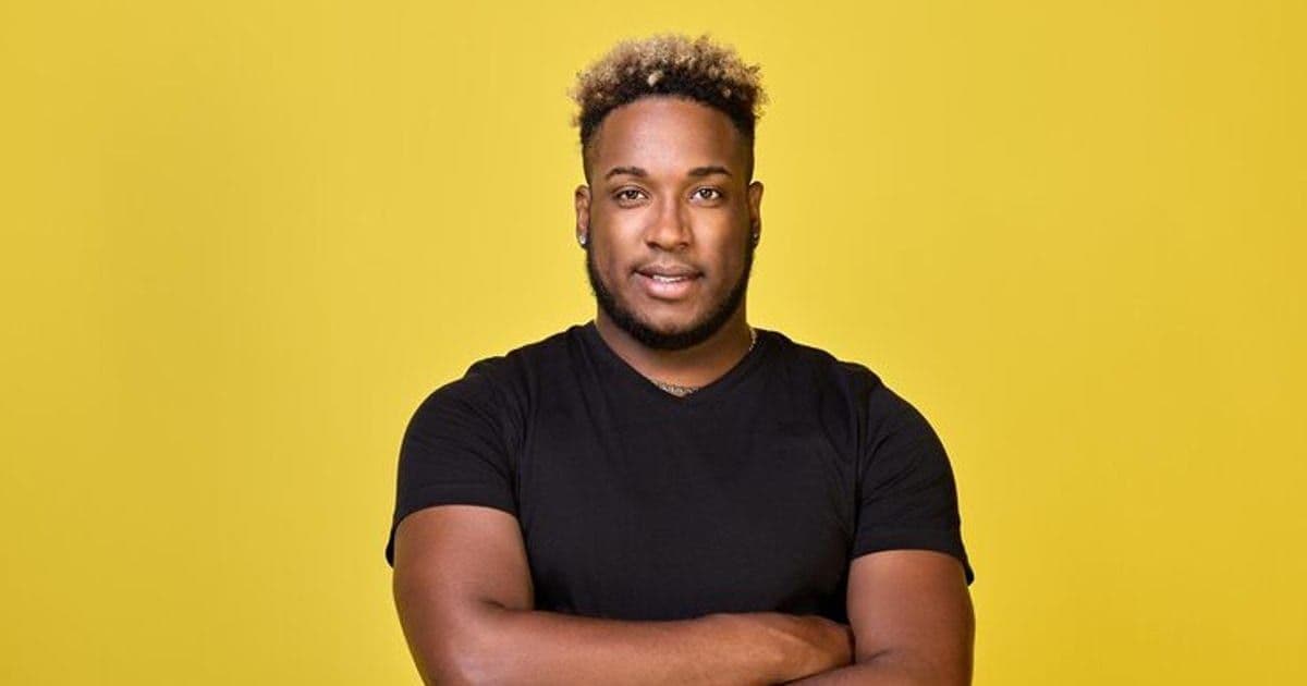 Stylish haircut of a pumpedup guy in a casual Tshirt on a yellow background